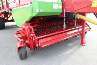 Červený sběrač Flex-Load pod zeleným vozem Strautmann