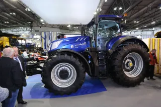 Modrý traktor New Holland vystavený v hale