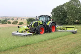 Traktor Claas se žacími stroji DISCO 9700 na louce