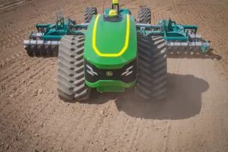 Zelený autonomní traktor John Deere při práci na poli