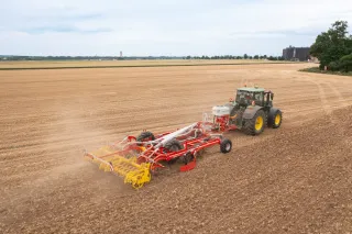 Traktor s radličkovým kypřičem Pöttinger při práci na poli