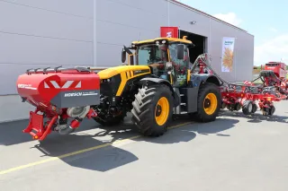 Traktor se secím strojem Horsch před budovou statku