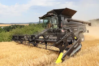 Černá sklízecí mlátička Fendt IDEAL při sklizni obilí