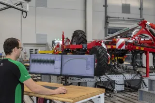 Technik u počítače testuje zemědělský stroj ve zkušebním centru Pöttinger