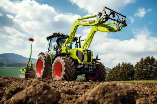 Traktor CLAAS AXOS s čelním nakladačem při práci na poli