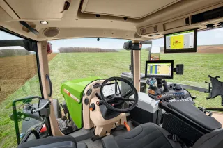 Pohled z kabiny traktoru Fendt na ovládací panely a pole