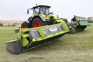 Traktor CLAAS se žací kombinací na louce