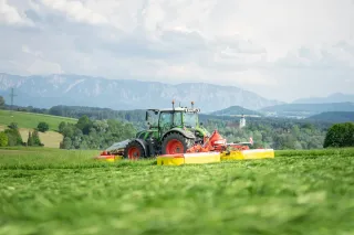 Traktor se žací kombinací Pöttinger na louce
