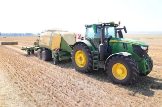 Traktor John Deere s lisem Krone BigPack na strništi