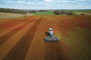 Traktor při práci na poli zachycený z výšky