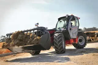 Teleskopický manipulátor Manitou převáží balík sena u stáje