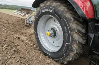 Detail pneumatiky Alliance na kole traktoru při práci na poli
