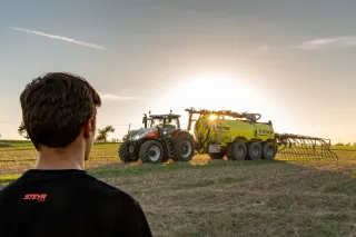 Traktor s aplikační cisternou Pichon na poli při západu slunce