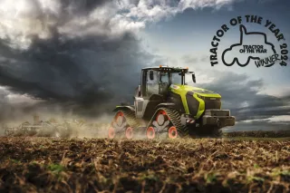 Pásový traktor Claas Xerion na poli s logem Traktor roku 2024.
