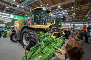 Zelený sklízecí stroj Krone BiG X s kukuřičným adaptérem na veletrhu Agritechnica.