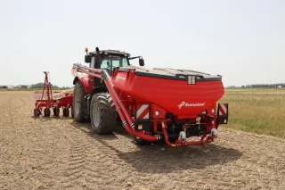 Červený čelní zásobník Kverneland f-drill na traktoru při setí