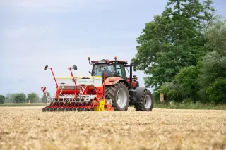 Traktor se secím strojem Pöttinger Vitasem na strništi