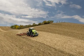Pásový traktor Claas Xerion při práci na svažitém poli