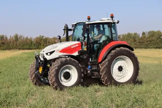 Bíločervený traktor Steyr Plus na poli