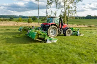 Traktor se žací trojkombinací SaMASZ při sečení louky