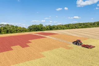 Traktor s kypřičem Väderstad TopDown na poli s barevně vyznačenými plochami