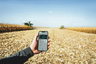 Mobilní aplikace Claas connect před polem s kombajny