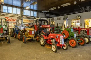 Skupina historických traktorů vystavených v hale Traktor klubu Luby-Skalná.