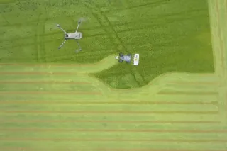 Letecký pohled na dron a zemědělský stroj v poli