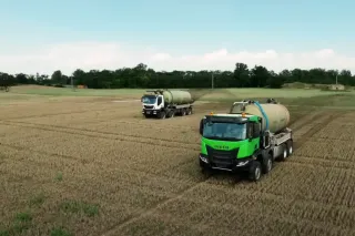 Dvě nákladní auta IVECO s cisternami na poli
