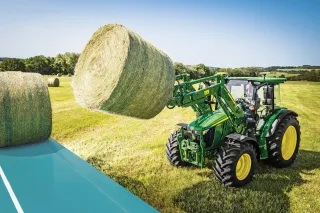 traktor John Deere 5M zvedající balík za pomoci čelního nakladače