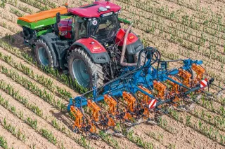 Traktor s meziřádkovou plečkou SCHMOTZER v poli