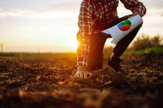 Zemědělec při kontrole půdy drží list s grafem