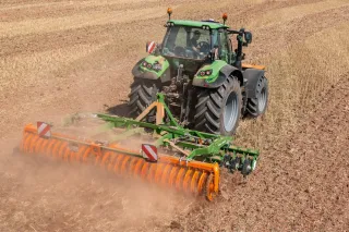 Traktor s diskovým podmítačem Amazone Catros na poli