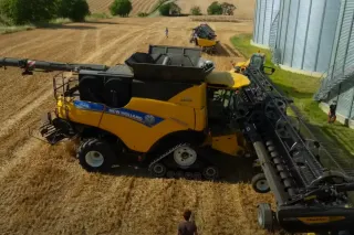 Sklízecí mlátička New Holland CR 9.90 u obilného pole