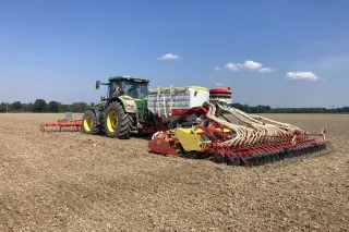 Traktor se secím strojem Pöttinger AEROSEM na poli