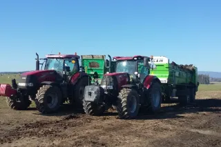 Dva traktory Case IH s přívěsy na poli