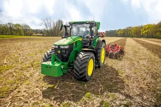 Traktor John Deere 7R s kypřičem na poli