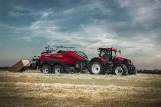Traktor Case IH s lisem na hranaté balíky na poli.