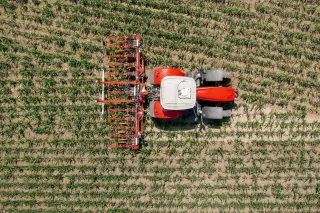 Traktor s plečkou Pöttinger při práci na poli z ptačí perspektivy
