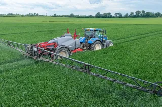 Traktor s postřikovačem Horsch Leeb na zeleném poli.
