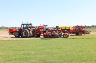 Traktor s několika secími stroji Väderstad na poli.