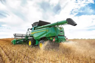 Sklízecí mlátička John Deere T5 sklízí obilí.