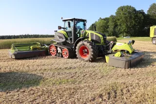 Pásový traktor CLAAS Axion Terra Trac s čelním a zadním žacím strojem.