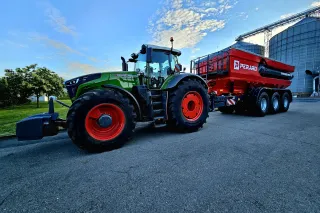 Traktor Fendt s červeným překládacím vozem Perard u sila.