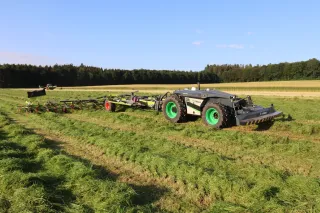 Autonomní robot AgXeed s obracečem CLAAS VOLTO na louce.