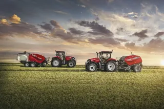 Dva červené traktory Case IH s lisy na poli.