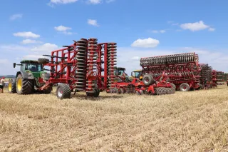 Traktory s červenými secími stroji Horsch na polním dni.