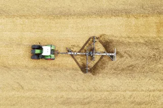 Letecký pohled na traktor s talířovými branami na poli.