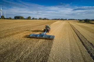 Letecký pohled na traktor s modrými talířovými branami Lemken.