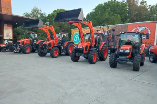 Traktory Kubota vystavené před budovou při oslavě výročí.